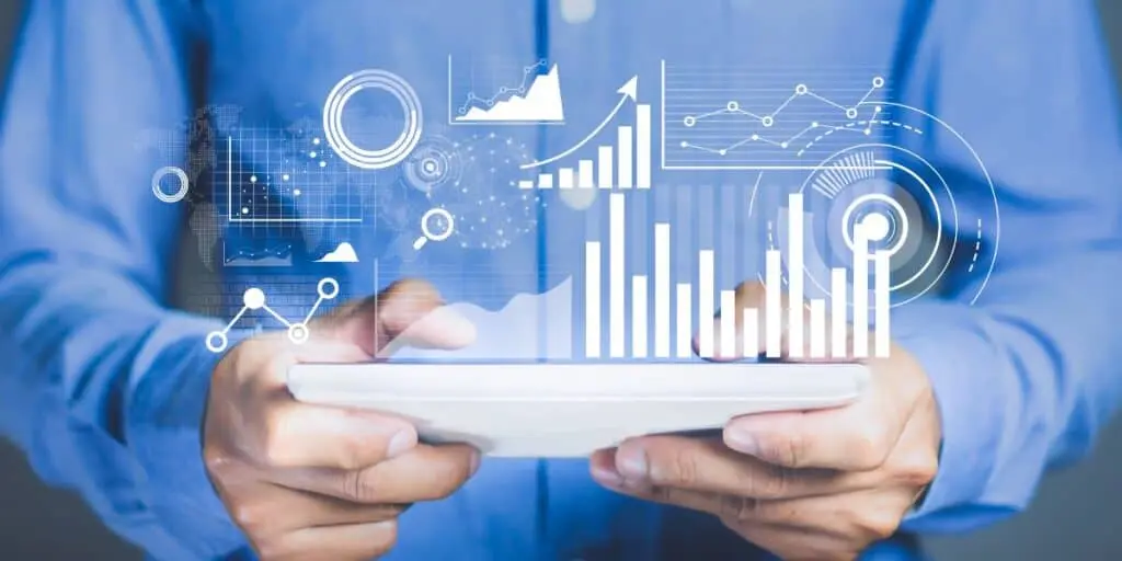 Intercambio de datos eficiente utilizando el protocolo MQTT junto con el middleware ZENTUP y análisis en tiempo real. Manos sosteniendo una tableta con gráficos digitales superpuestos que muestran análisis de datos en tiempo real mediante el protocolo MQTT y ZENTUP.